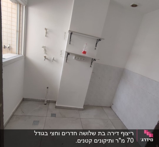 חדר ריק עם אריחים חדשים, מדפים וברזים מותקנים